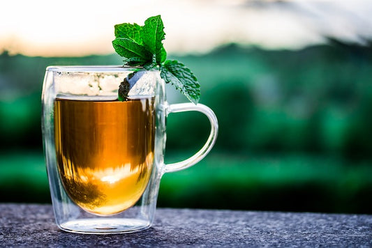 Fresh antioxidant-rich tea in a glass cup outside