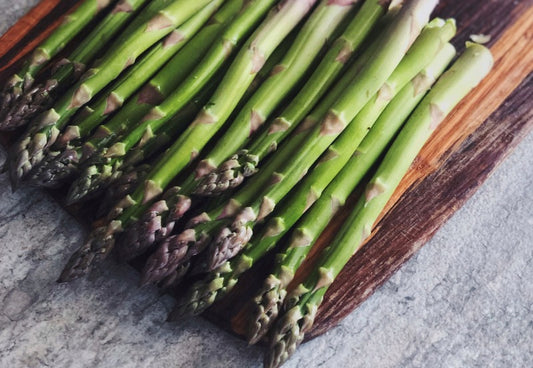 Lots of raw asparagus on a countertop 